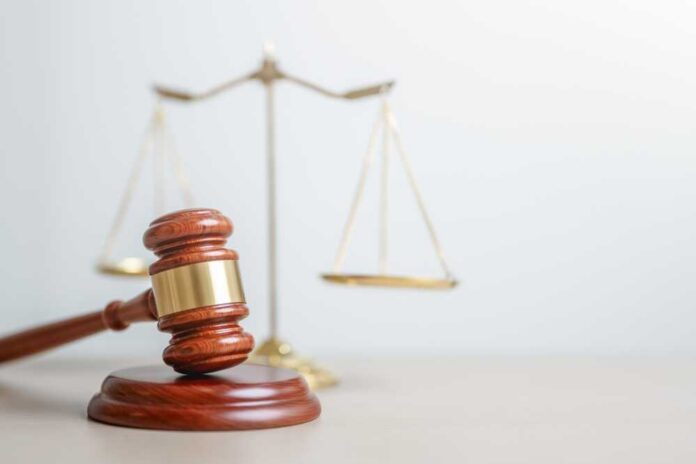 Law,Concept.,Justice,Criminal,Legal.,Hammer,Judge.,Lawyer,Judgment,Gavel. A wooden gavel in front of a balance scale symbolizing justice
