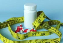 Old Pill TORCHES Fat — Muscle Spared? A white pill bottle surrounded by red and white capsules and a yellow measuring tape