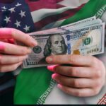 Hands holding a $100 bill with American and Iranian flags in the background