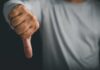 A hand showing a thumbs down gesture