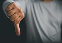 A hand showing a thumbs down gesture
