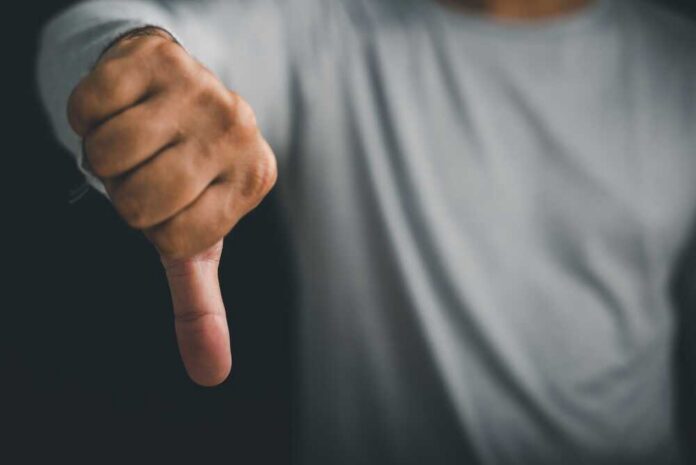 Closeup,Of,A,Man,Hand,Pose,With,A,Thumbs,Down A hand showing a thumbs down gesture
