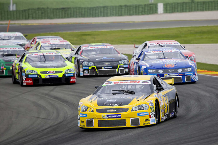 Valencia,,Spain,-,April,25:,Some,Cars,Compete,At,Race Race cars on Daytona track with large audience watching