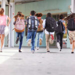 42 States vs. Meta Heats Up Children running with backpacks outside a school building.