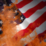 American flag partially set on fire with orange flames.