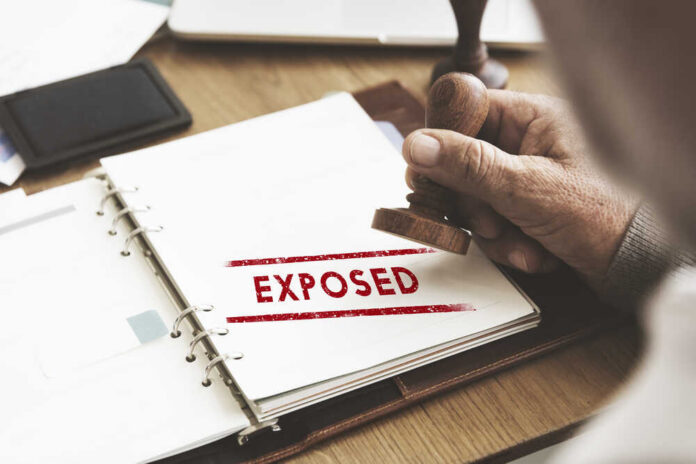Exposed,Disclosed,Declarative,Indicative,Relating,Concept A hand stamping the word 'EXPOSED' on a document