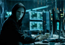 Shocking Crypto Heist By Illegal: $240M Vanishes Person in hoodie and mask using computer, multiple screens.