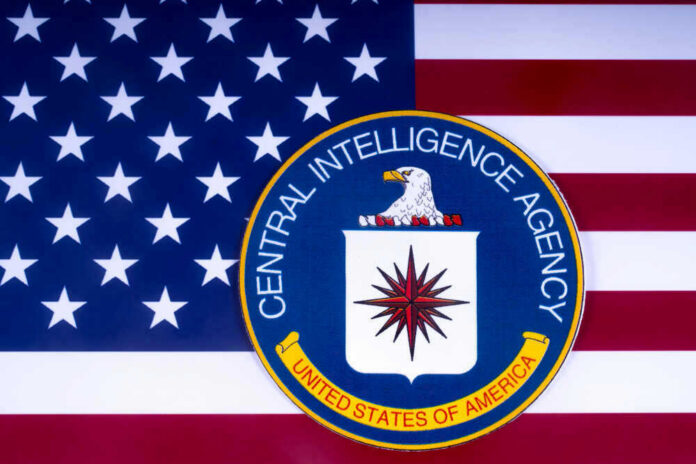 shutterstock_1051373186 CIA emblem over United States flag background.