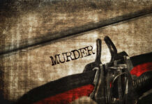 Mix-Up Ends in Mass Graves Close-up of metal handcuffs on a grungy surface with the word MURDER