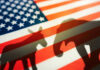 GOP, Dems Slam Trump Donkey and elephant shadows on American flag background.