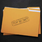 Top Secret Files Demand Daylight Yellow folder labeled Top Secret on black background.