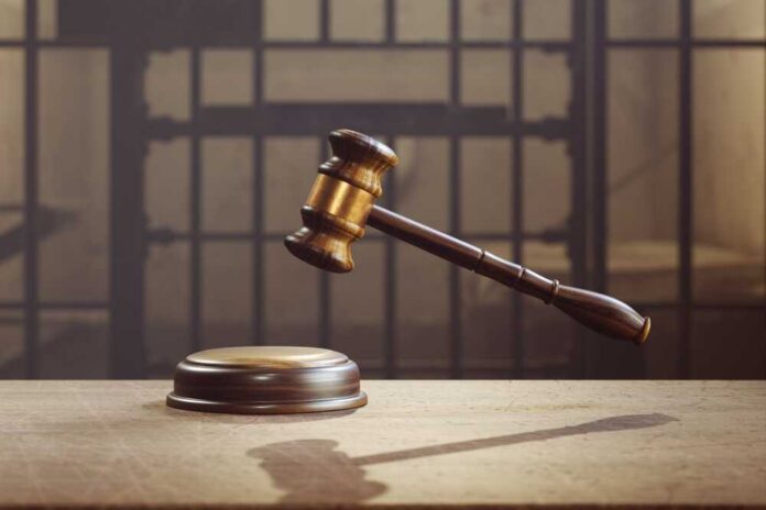 The,Image,Symbolizes,The,Verdict,Of,The,Prosecution,For,The judge's gavel hovering above sound block in front of jail bars