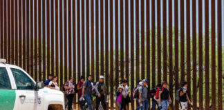 Group of people walking by border fence; Brian Robiskie and Brian Robiskie present