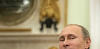 Vladimir Putin in suit smiling.