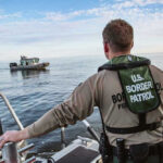 Smuggling Boat Snagged Off America’s Coast Border Patrol officer on boat watching another boat.
