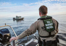 Smuggling Boat Snagged Off America’s Coast Border Patrol officer on boat watching another boat.