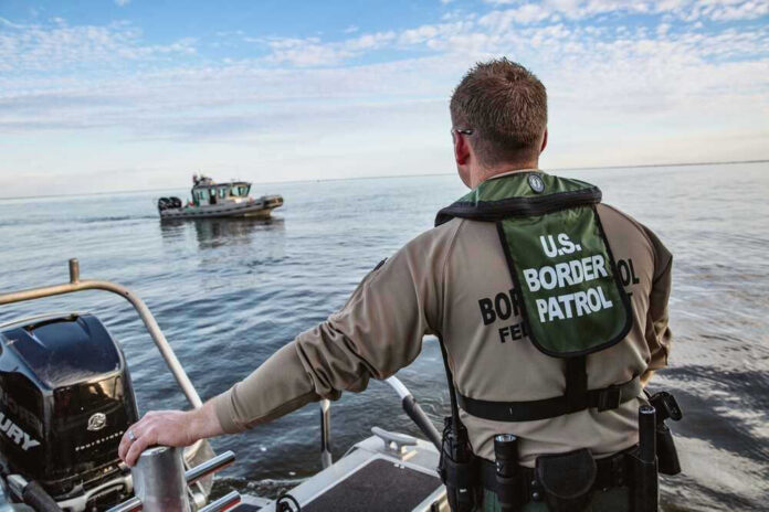 Border Patrol officer on boat watching another boat.