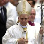 Catholic bishop in white vestments holding a crosier