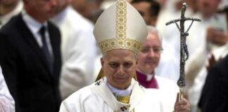 Catholic bishop in white vestments holding a crosier