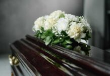 Shocking: TV Star Dead A floral arrangement of white roses and greenery on a polished casket