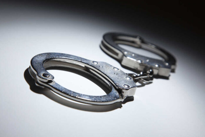 Close-up of metallic handcuffs on a light surface